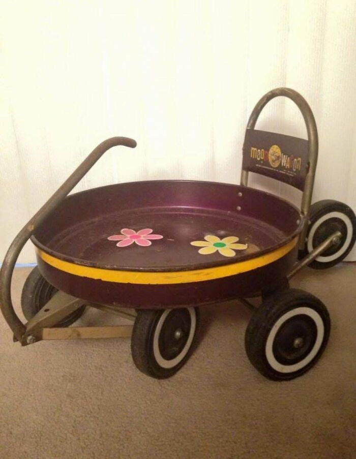 Vintage toy wagon with floral designs, featuring a retro circular seat and four wheels.