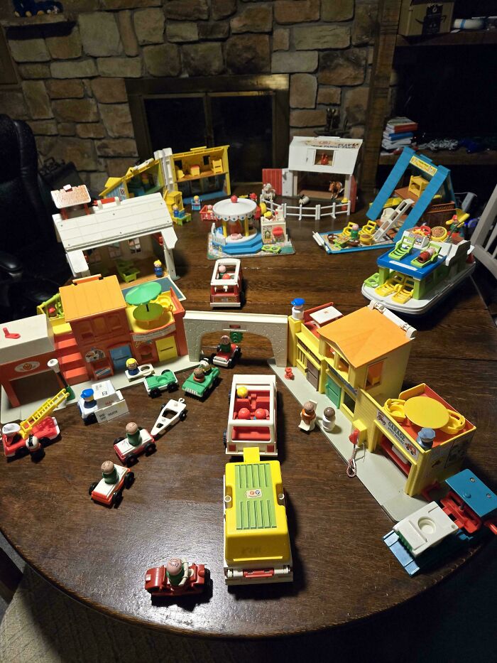 Vintage toys arranged on a table, featuring colorful playsets and vehicles in a nostalgic setting.