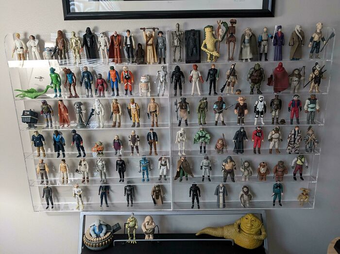Vintage toys displayed on a wall shelf, showcasing a collection of classic action figures from childhood memories.