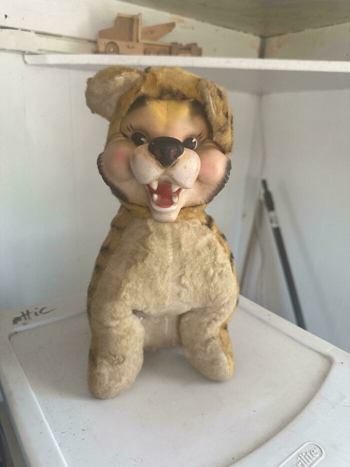 Vintage toy tiger with a friendly expression, sitting atop a white shelf in a nostalgic display setting.