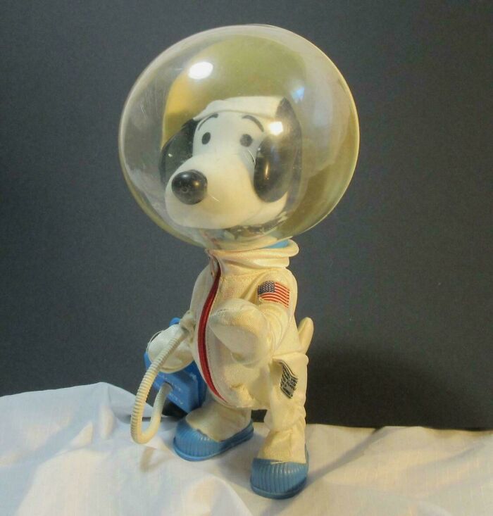 Vintage toy dog in astronaut suit with helmet, evoking childhood memories.