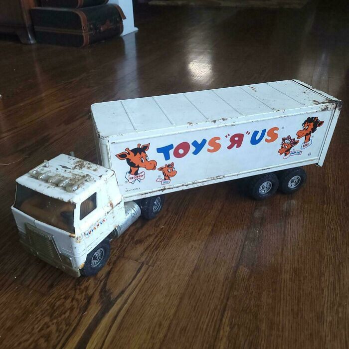 Vintage Toys R Us truck toy on wooden floor, reminiscent of childhood nostalgia.