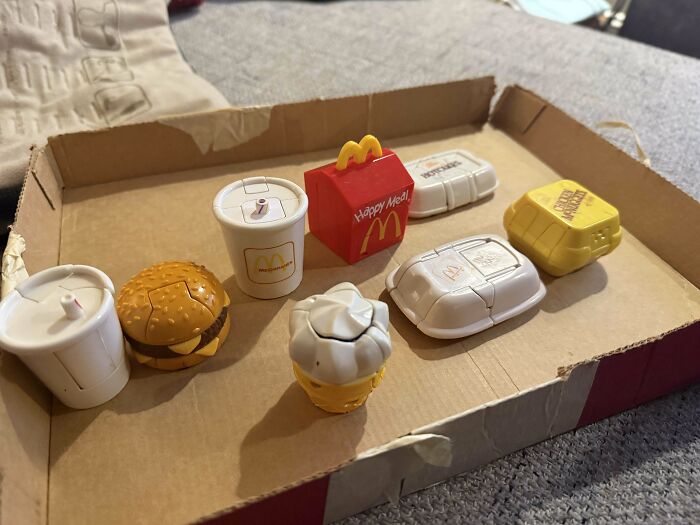 Vintage toys resembling fast-food items in a cardboard box.