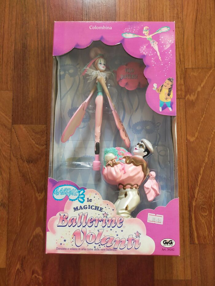 Vintage toy ballerina Colombina in original packaging on a wooden floor.