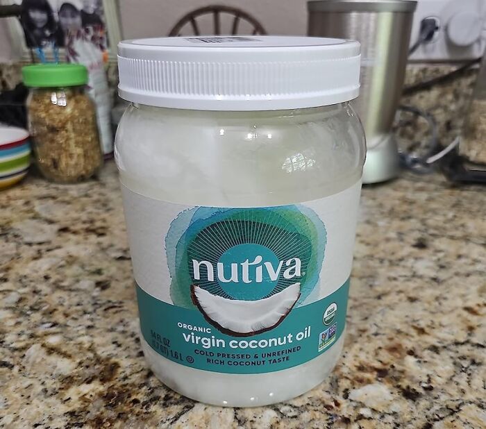 Jar of virgin coconut oil on a kitchen counter, showcasing an old school beauty hack ingredient still popular today.