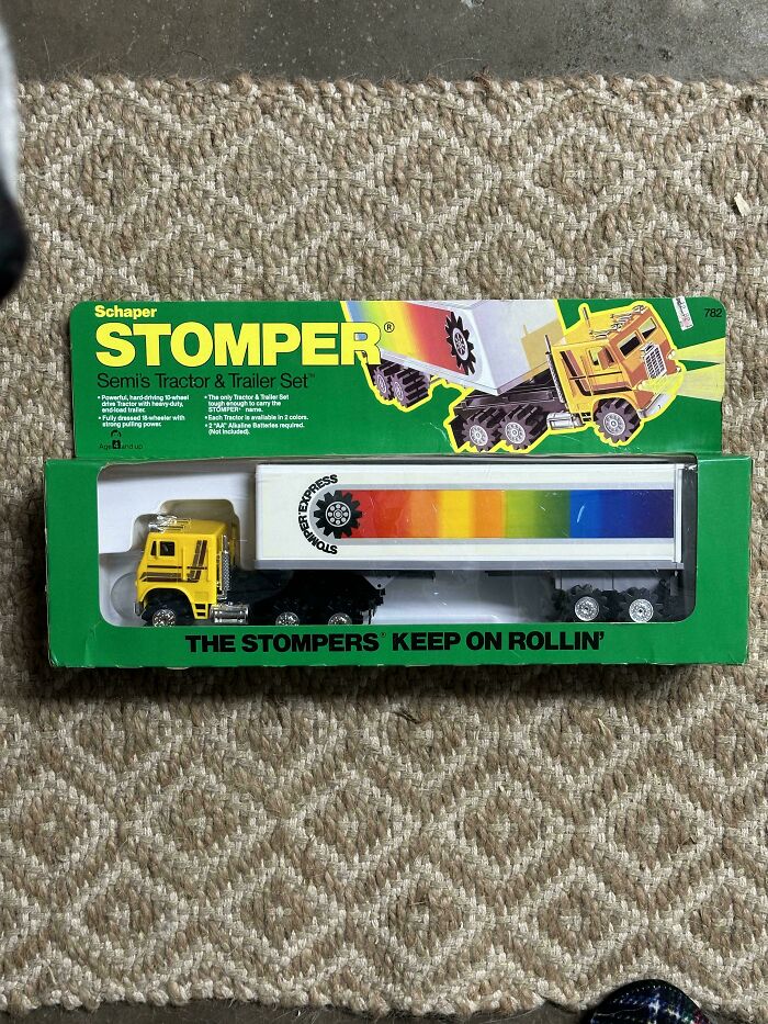 Vintage toy truck set in packaging, featuring a yellow semi tractor and colorful trailer.