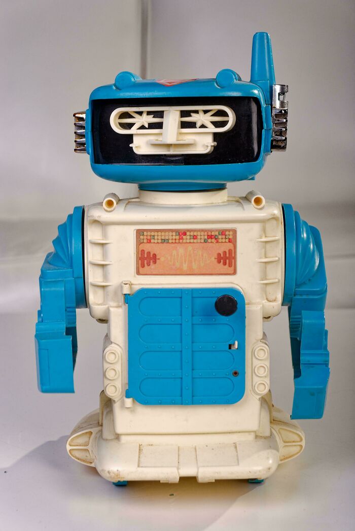 Vintage toy robot with blue arms and antenna, evoking childhood nostalgia.