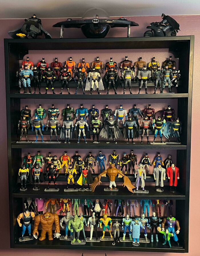 Collection of vintage Batman toys displayed on a black shelf.