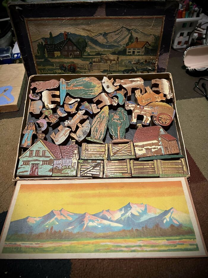 Vintage toys depicting farm life with wooden puzzle pieces and illustrated box art showcasing rural scenes and mountains.