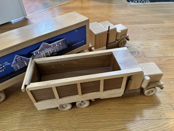 Wooden vintage toy trucks on a wooden floor, showcasing nostalgic childhood playthings.
