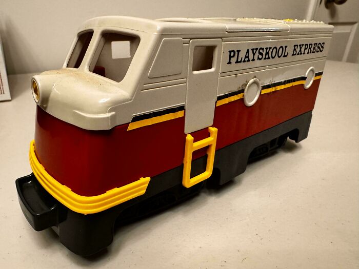 Vintage toy train labeled "Playskool Express" with red, white, and yellow details on display.