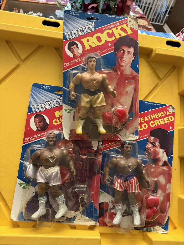 Vintage action figures of iconic movie boxers Rocky, Apollo Creed, and Clubber Lang on display in original packaging.