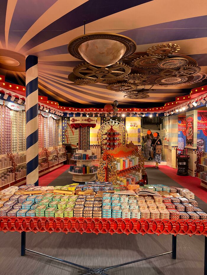 Colorful market stall with canned goods, under a decorative ceiling, offering interesting tourist experiences.