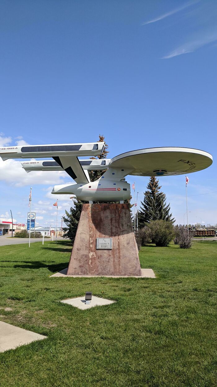 Starship monument on a pedestal in a green park offers Tourist-Interesting-Experiences under a clear blue sky.