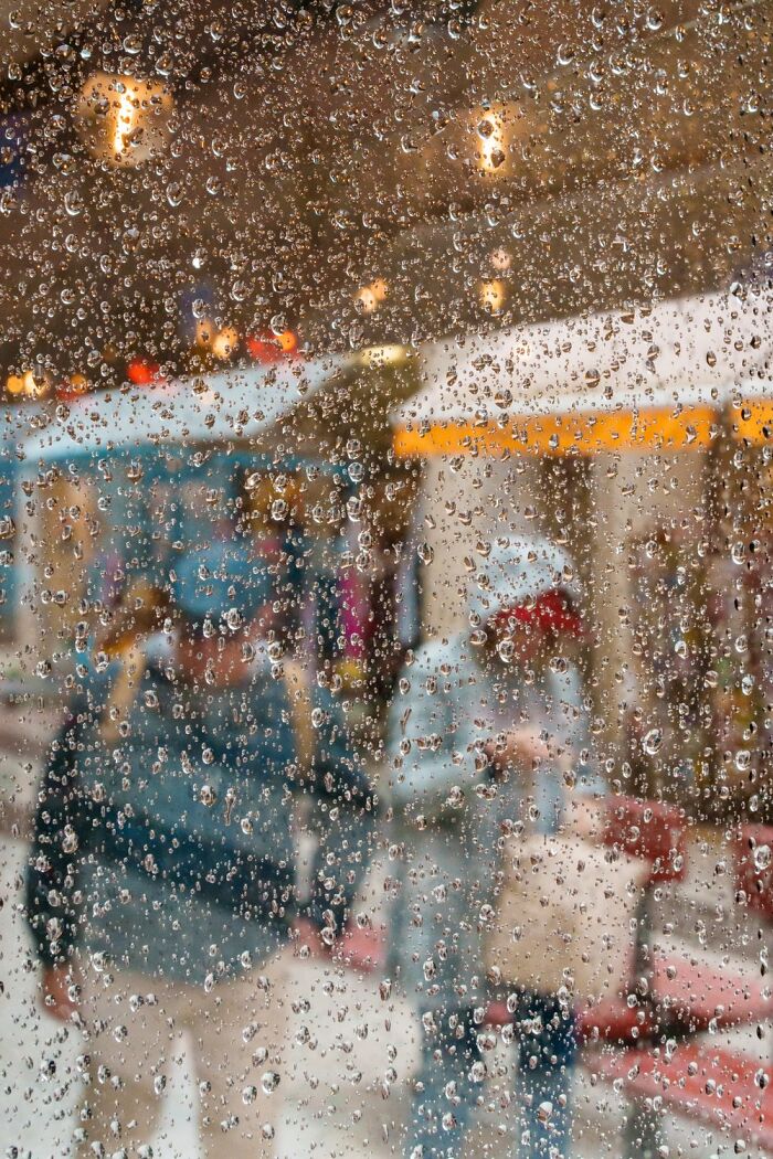 Raindrops on a window obscure a view of Oslo’s streets, capturing the essence of urban life.