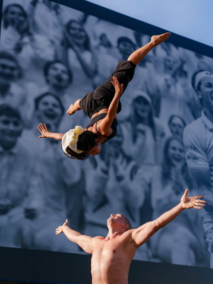 Acrobats performing a stunt on the streets of Oslo; André captures street essence with a dynamic action shot against a crowd backdrop.