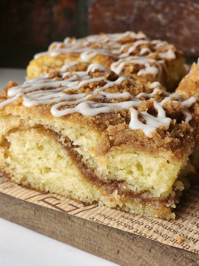 Close-up of an incredible bake with cinnamon swirl and icing drizzle, showcasing a moist and crumbly texture.
