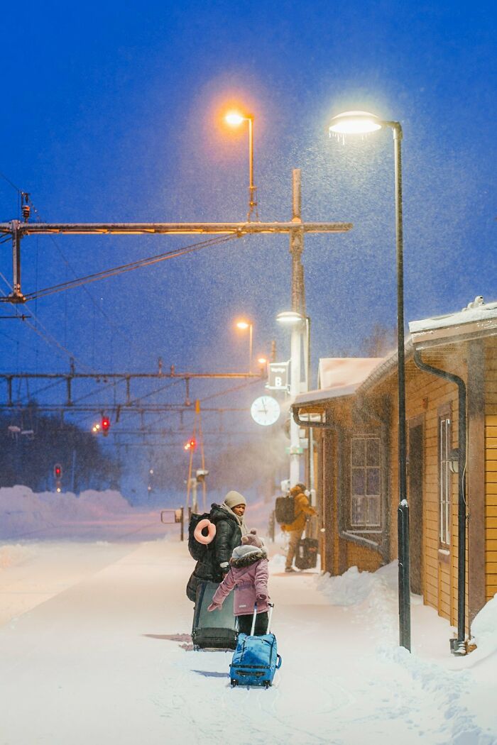 People navigating snowy streets of Stockholm, silhouetted by streetlights, capturing the city's winter essence.