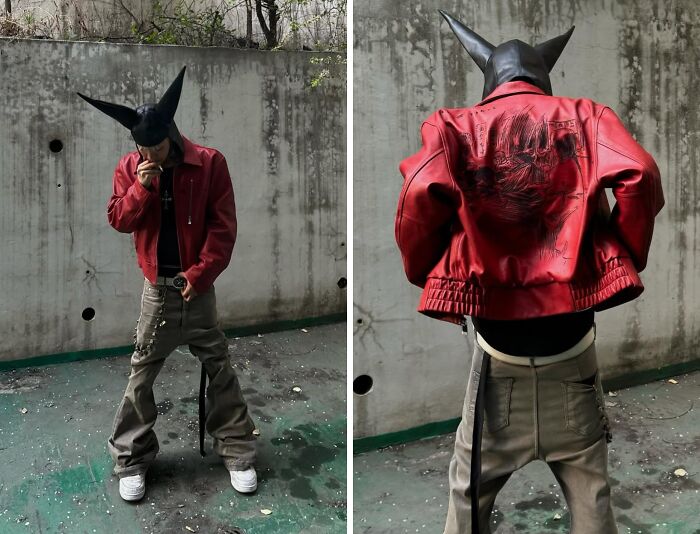 Fashion risk taker in red leather jacket and black mask, confidently posing outdoors.