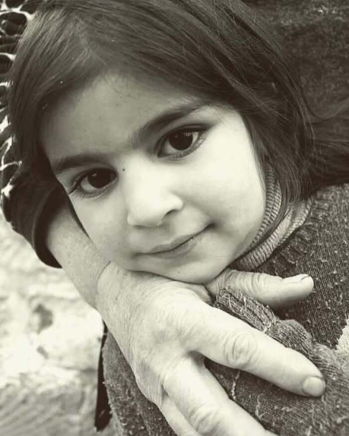 Black and white photo of a child embraced, capturing childhood innocence and resilience.