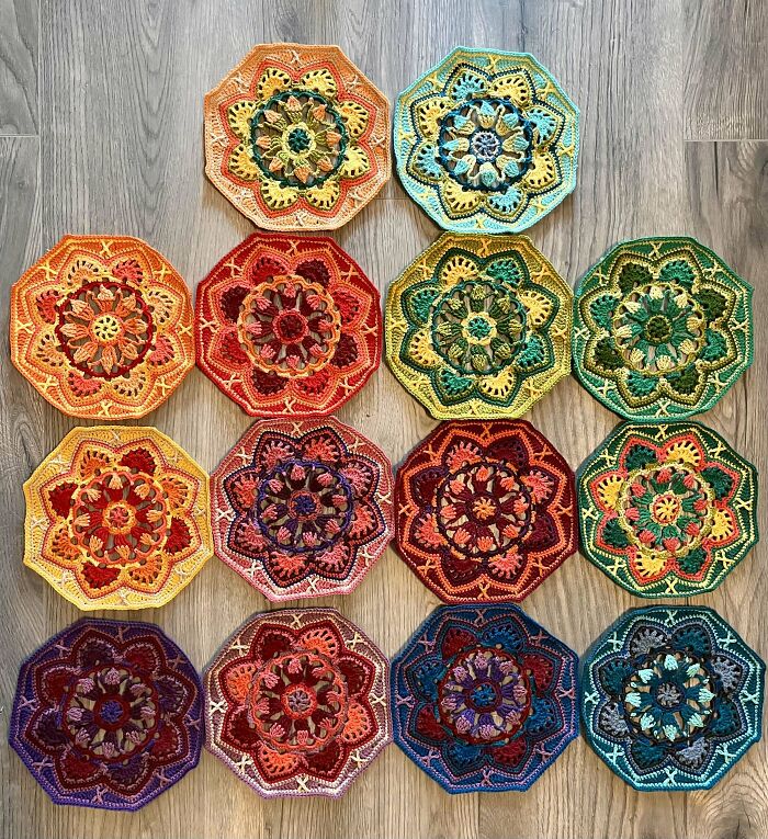 Colorful octagonal crochet pieces arranged on a wooden floor showcasing detailed crochet masterpieces.