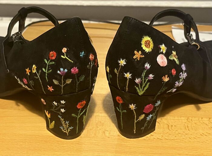 Black heels decorated with beautiful and intricate colorful floral embroidery showcasing impressive embroidery skills.