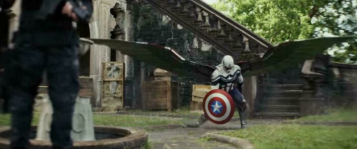Winged character holding a shield stands in front of stone stairs and crates, highlighting questionable movie details mocked online.