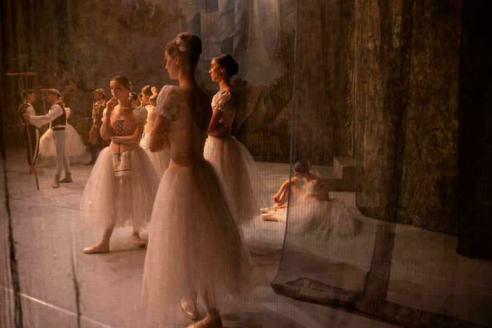Ballet dancers in a dimly lit backstage scene, resembling an Accidental Renaissance painting.