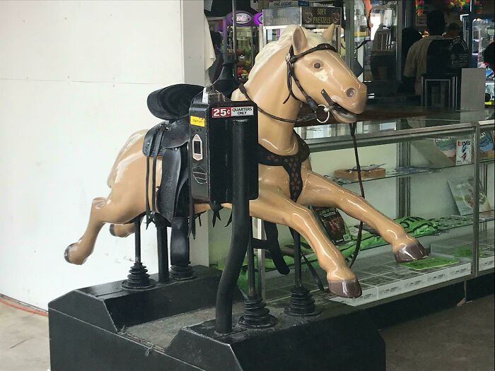 Coin-operated horse ride evokes nostalgia in a mall setting.
