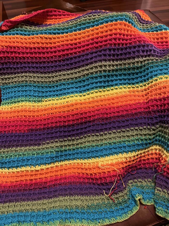 Colorful striped crochet blanket showcasing intricate stitch patterns and vibrant hues in a cozy handmade crochet masterpiece.