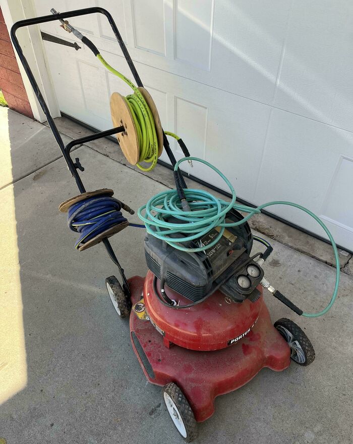 Redneck engineer invention turning a lawn mower into a mobile air compressor with hose reels attached for easy access.