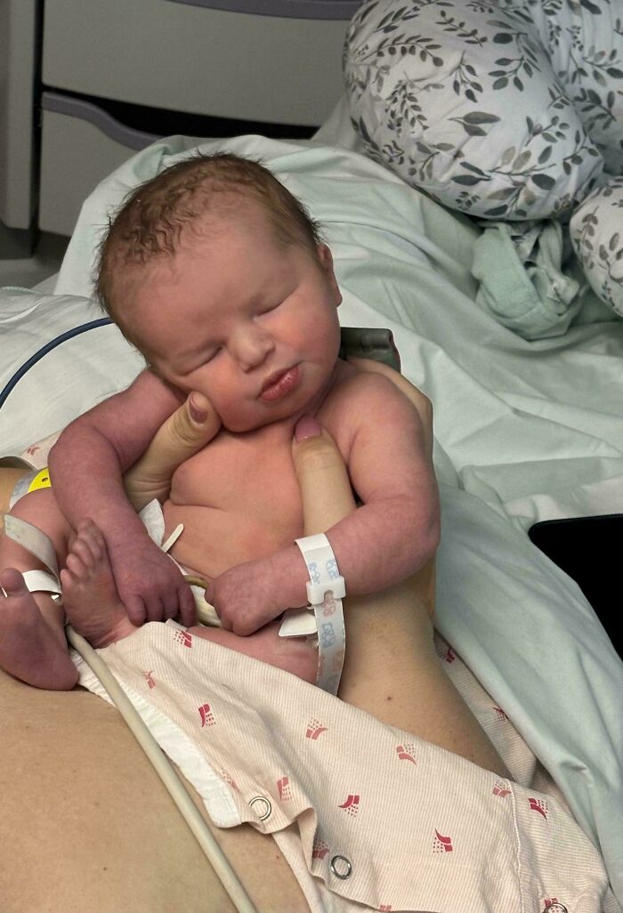 Newborn baby cradled gently showing wholesome dads doing their best parenting moments in a tender hospital setting.