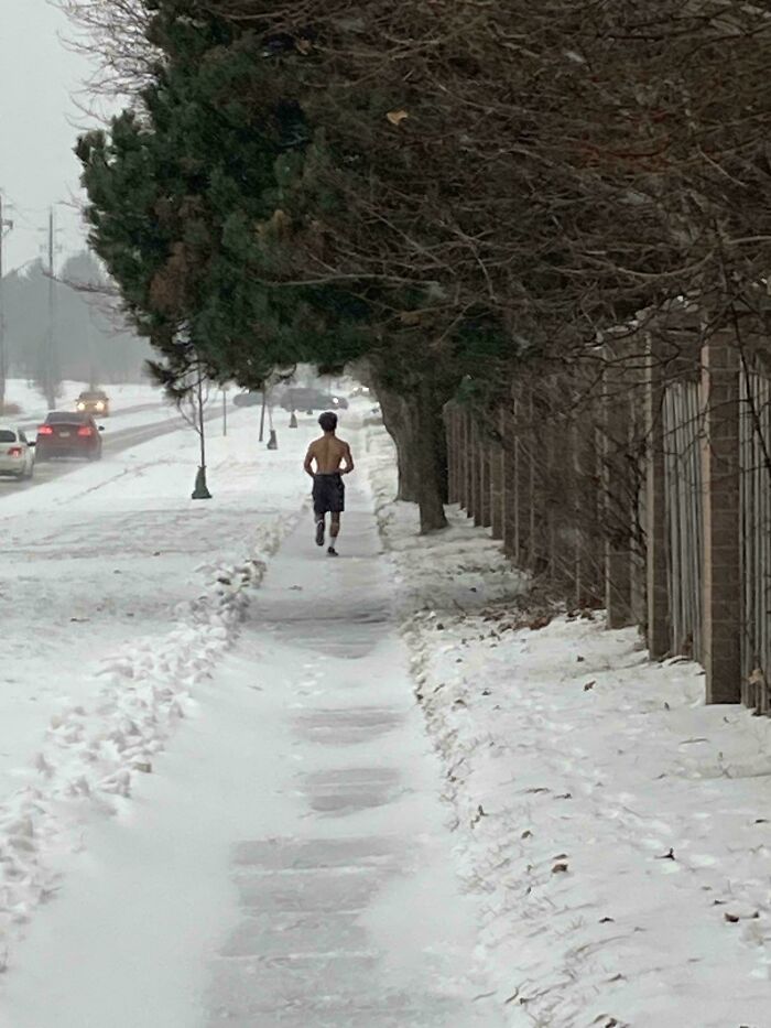 Man jogging shirtless on a snowy sidewalk, illustrating Just Canada Things.