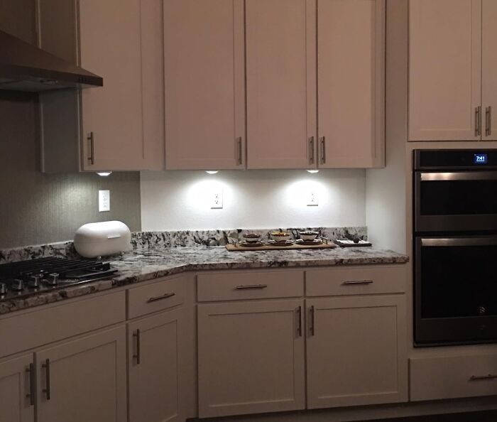 Modern kitchen with white cabinets and granite countertops, showcasing clever ways to transform things you already own.