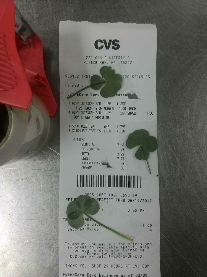 Unique CVS receipt with four-leaf clovers placed on it, a truly interesting find among receipts.