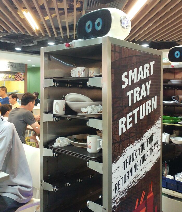 Smart tray return system in a busy restaurant, offering tourists interesting experiences with automated service.