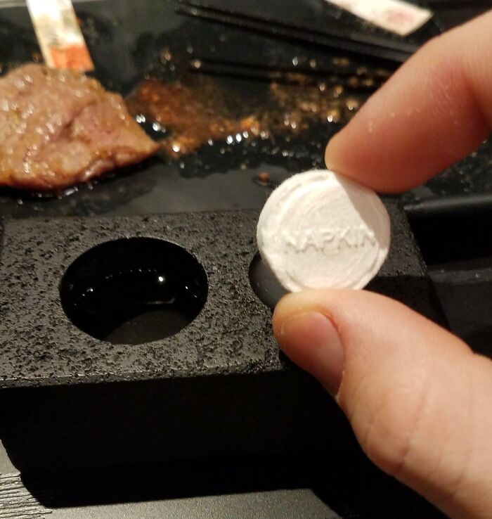 Compressed napkin expanding in water, showcasing a tourist-interesting experience at a restaurant table.