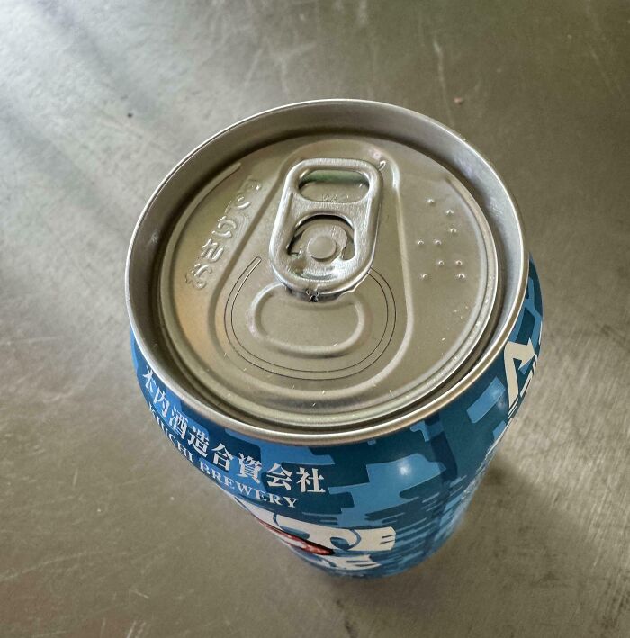 A blue beverage can with foreign text offers tourist interesting experiences.