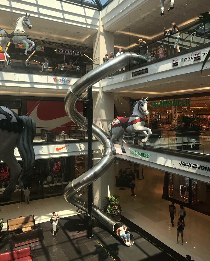 Shopping mall with a large spiral slide and carousel horses offers tourist interesting experiences.