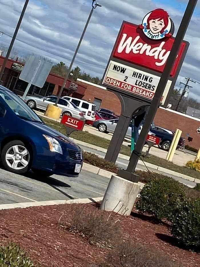 Wendy's sign humorously displays "Now hiring 2 losers," illustrating a "recruiting hell" scenario.