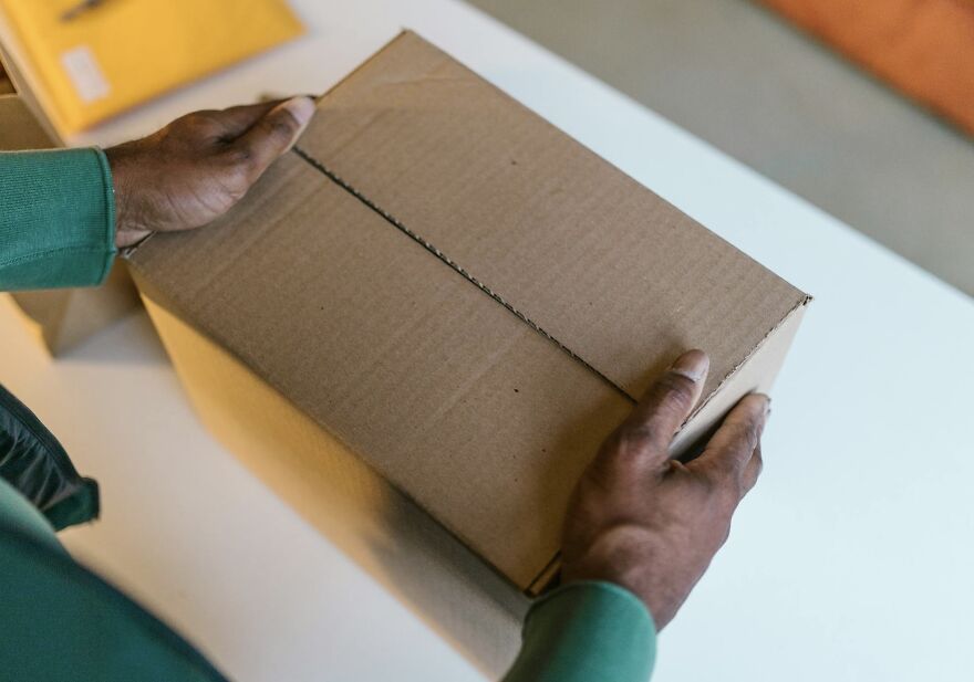 Person holding a cardboard box, possibly indicating an ethical dilemma or decision-making scenario.