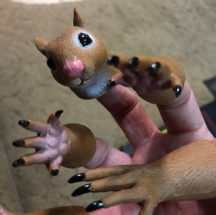 Fingers wearing Archie Mcphee squirrel finger puppets with detailed claws and face.