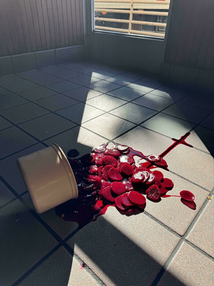 Spilled container of sliced beets on tiled floor, resembling an accidental Renaissance painting.