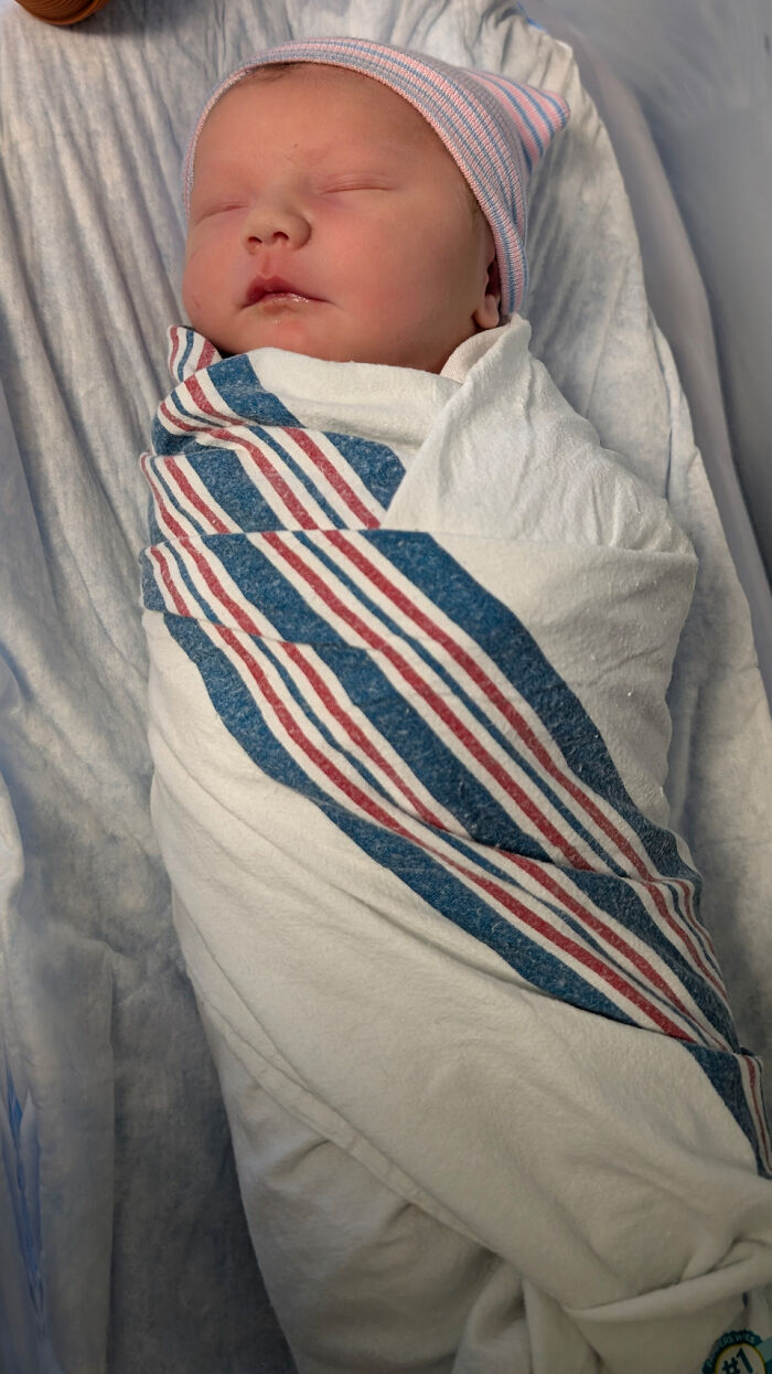 Newborn baby peacefully sleeping wrapped in a blanket, capturing wholesome parenting moments with dads.