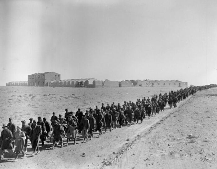 Soldiers march in a long line across a desert landscape during one of history's surprising war victories.