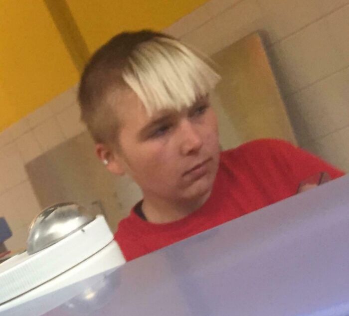 1980s hairstyle with blonde bangs and brown sides, showcasing an epic hair disaster in a casual setting.