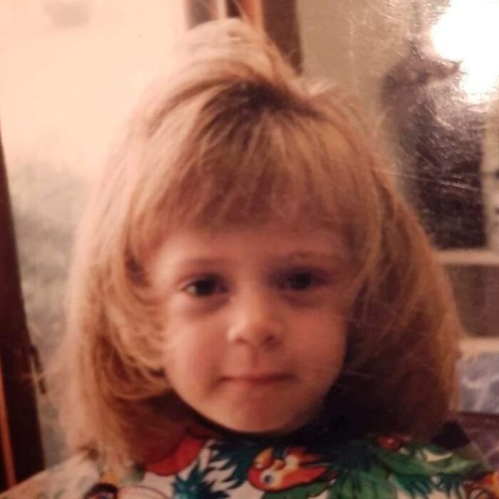Child with voluminous 80s hairstyle, showcasing a playful hair disaster theme.