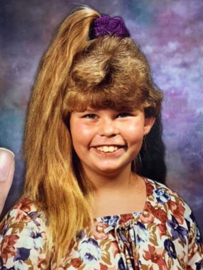 Child with an iconic high ponytail and thick bangs, showcasing classic 1980s hair style.