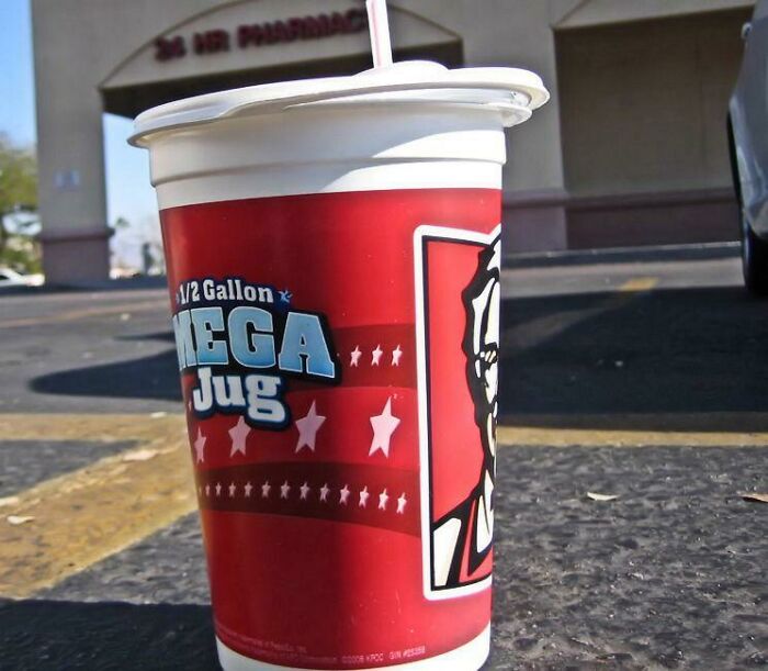 Large American soda cup in a parking lot, showcasing a cultural norm that surprises international visitors.