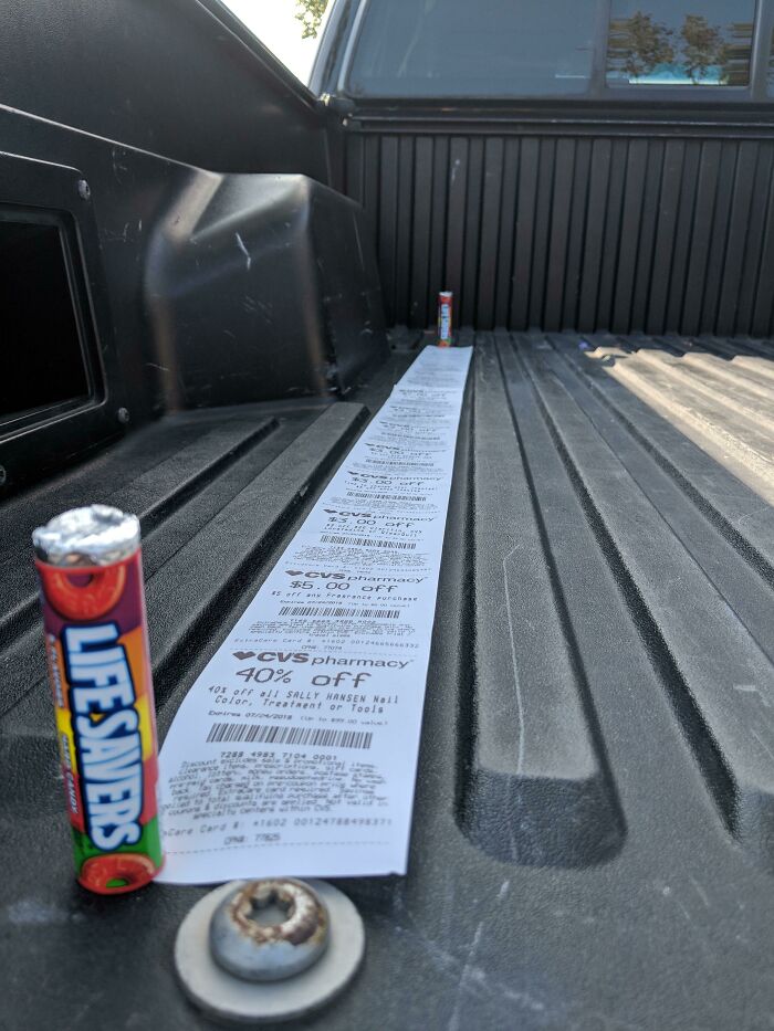 Long CVS receipt stretched out in a truck bed next to Lifesavers candy, showcasing interesting receipts people found.